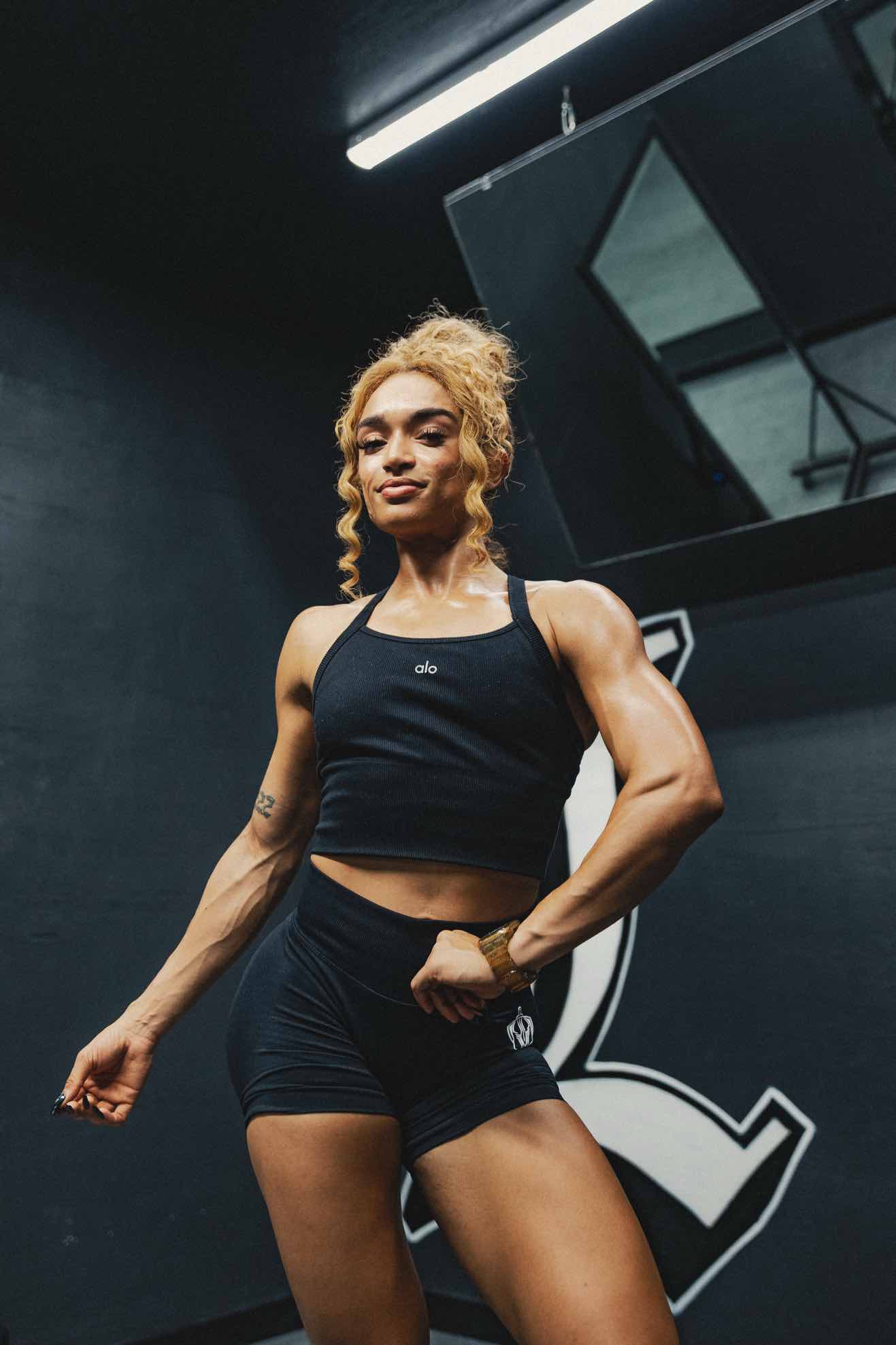 Athlete flexing in a dark gym